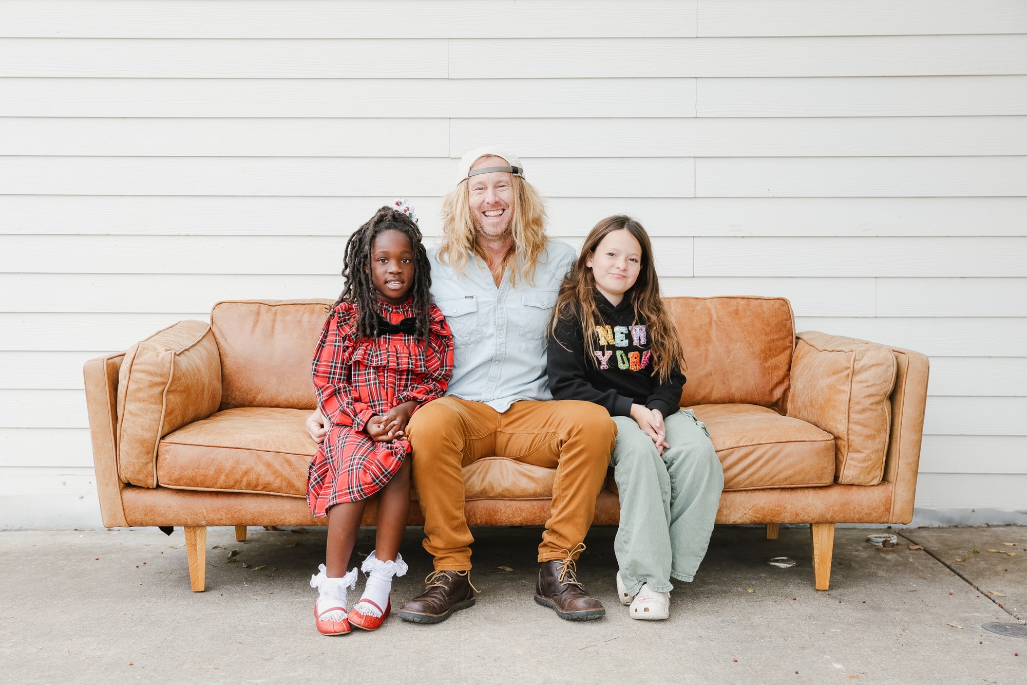 Jamey and his daughters on the couch — the reason Honest exists.